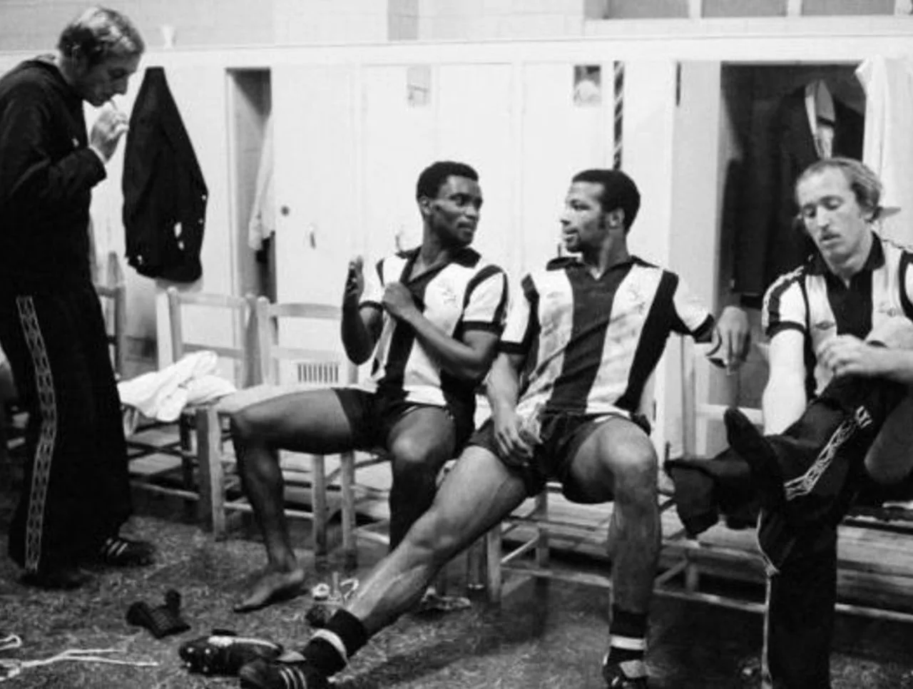 West Bromwich Albion players in striped shirts talking in a dressing room before a match